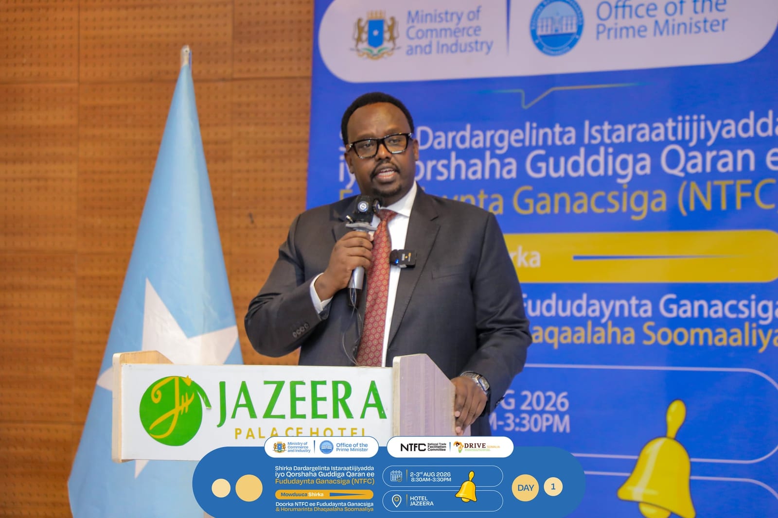 A speaker addresses delegates beside the Somali flag